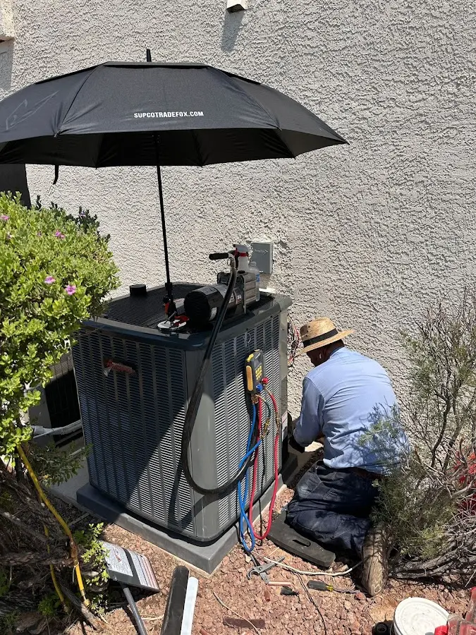 HVAC technician performing outdoor AC maintenance in Harrison